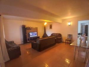 sala de estar con sofá y TV en Casa com piscina Laranjal, en Pelotas