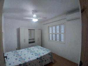1 dormitorio con cama y ventana en Casa com piscina Laranjal, en Pelotas