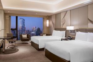 Pokój hotelowy z 2 łóżkami i biurkiem w obiekcie JW Marriott Hotel Chengdu w mieście Chengdu