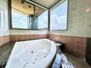 a large bath tub in a bathroom with a large window at K2 SKY Resort Itoshima Love Hotel in Itoshima