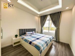 sypialnia z łóżkiem i oknem w obiekcie Sky House Apartment w Tam Kỳ