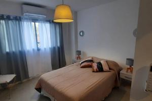 a bedroom with a large bed with a light fixture at Departamento moderno en Las Lomitas in Lomas de Zamora