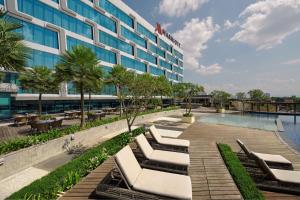 a hotel with a swimming pool and lounge chairs at Yogyakarta Marriott Hotel in Yogyakarta
