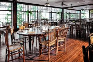 a dining room with tables and chairs and windows at The Historic Crag's Lodge in Estes Park