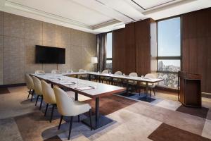 une salle de conférence avec une grande table et des chaises dans l'établissement Four Points by Sheraton Josun, Seoul Station, à Séoul