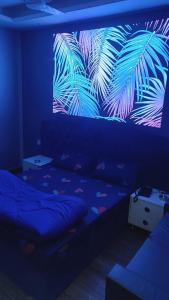 Schlafzimmer mit einem Bett und einem Palmenmilch in der Unterkunft Vinanda Home Stay in Neu-Delhi
