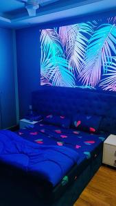 Schlafzimmer mit einem Bett und einem Wandbild aus Blättern in der Unterkunft Vinanda Home Stay in Neu-Delhi