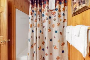 a bathroom with a shower curtain with autumn leaves on it at The Hydeaway in Hiawassee +24 photos