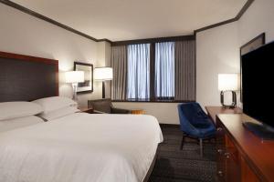 a hotel room with a bed and a flat screen tv at Sheraton Anchorage Hotel in Anchorage