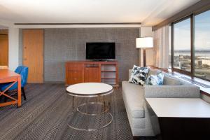 a living room with a couch and a tv at Sheraton Anchorage Hotel in Anchorage