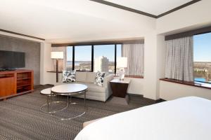 a hotel room with a bed and a couch and a tv at Sheraton Anchorage Hotel in Anchorage
