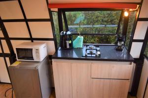 a small kitchen with a microwave and a refrigerator at Chalet Petit Verdot in Medellín