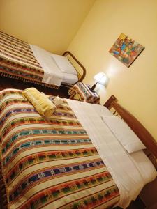 Un dormitorio con una cama con una colcha colorida. en Hostal Torotoro en Torotoro