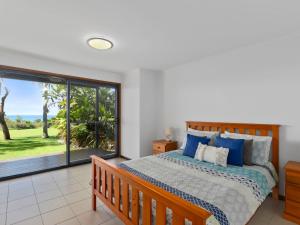 a bedroom with a bed and a large window at Surf Break in Arrawarra