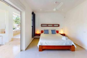 1 dormitorio con 1 cama con almohadas azules en Casa Jasmin~7000 m2 of tropical garden, en Las Terrenas