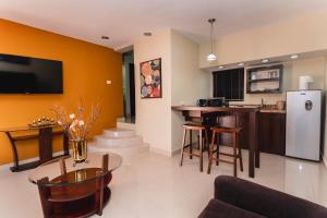 eine Küche und ein Wohnzimmer mit einem Kühlschrank und einem Tisch in der Unterkunft El Camino Hotel & Suites in Heroica Caborca