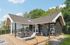 エーベルトフトにあるStunning Home In Ebeltoft With 3 Bedrooms And Wifiの小さな家で、デッキ(テーブル、椅子付)が備わります。