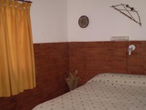 1 dormitorio con cama y pared de ladrillo en Hotel Foxes en Villa del Dique