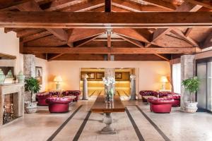 a living room with red chairs and a fireplace at Sheraton Rome Parco de Medici in Rome