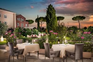 um restaurante com mesas e cadeiras num jardim em Sheraton Rome Parco de Medici em Roma