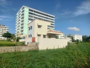 a tall building in a field next to a building at Sathya Sai Nivas in Puttaparthi