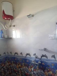 a wall with a bunch of dolphins on it at Sathya Sai Nivas in Puttaparthi