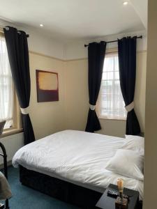 a bedroom with a bed with black curtains at The Star Inn in Ringwood