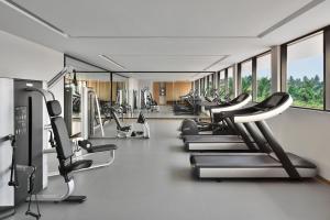 a gym with a row of treadmills and machines at Port Muziris, A Tribute Portfolio Hotel in Nedumbassery