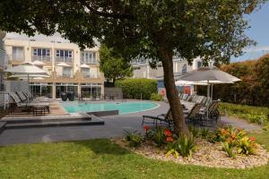 a resort pool with lounge chairs and an umbrella at Protea Hotel by Marriott Knysna Quays in Knysna