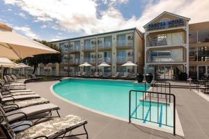 a hotel with a swimming pool and chairs and a building at Protea Hotel by Marriott Knysna Quays in Knysna