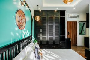 a bedroom with a bed and a blue wall at Lamy's House Cần Thơ in Can Tho
