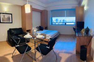 un soggiorno con letto, tavolo e sedie di Cozy suite asombrosa ubicación a Città del Messico