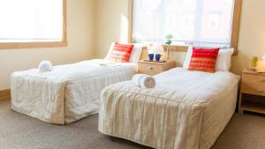 two beds sitting next to each other in a bedroom at Kamakura Apartments in Kutchan +17 photos