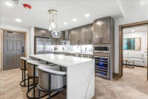 una cocina con una gran isla blanca con taburetes de bar en Ski in/out at Westgate, Remodeled 1BR, Resort amenities, Mutiple Pools, Spa, and Restaurant 4503A en Park City