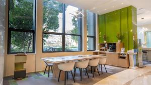 a kitchen with green walls and a table and chairs at Holiday Inn Express Nantong Xinghu, an IHG Hotel in Nantong