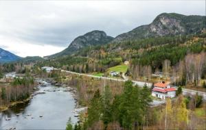 um rio num vale com uma casa e montanhas em Holiday Home em Gol