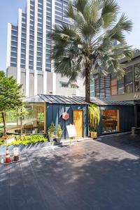 فندق Ariston Bangkok في بانكوك: نخلة أمام المبنى