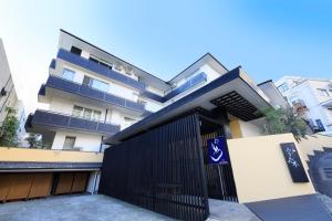 Un edificio con un cancello nero davanti di Yuyado Mikannoki ad Atami