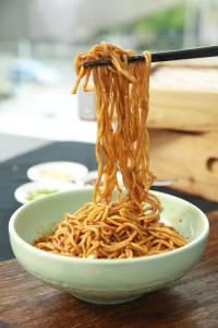 un tazón de fideos con un par de palillos chinos en Sheraton Grand Wuhan Hankou Hotel - Let's take a look at the moment of Wuhan en Wuhan