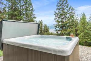 a jacuzzi tub in the backyard with trees at Heaven's Haven in Vernon
