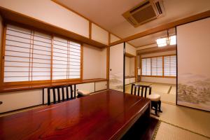 a room with a table and chairs and windows at Oyado Uraku in Yufu
