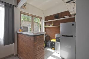 a kitchen with a refrigerator and a brick wall at ImahBC Surfcamp in Tabanan
