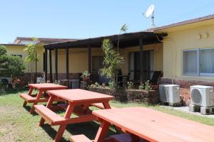 a group of picnic tables in front of a house at 北谷 vacation house MALAPUA in Chatan