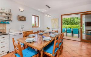 Il comprend une cuisine et une salle à manger avec une table et des chaises en bois. dans l'établissement Beautiful Home In Dobrinj With Outdoor Swimming Pool, à Dobrinj
