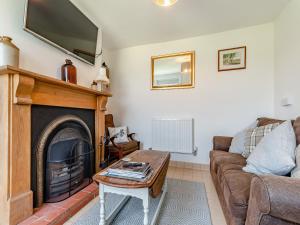 a living room with a couch and a fireplace at Diglis Lock Cottage in Worcester