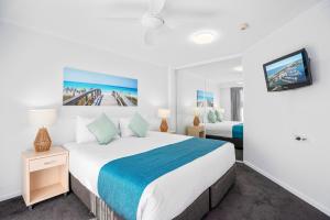 um quarto com uma cama grande e uma televisão em Sovereign on the Gold Coast em Gold Coast