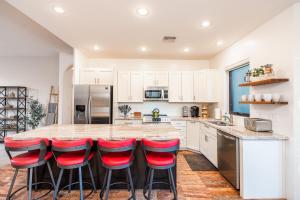 a kitchen with a large island with red bar stools at WEST SEDONA RETREAT w/ VIEWS of Coffee Pot Rock! in Sedona