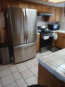 a kitchen with a stainless steel refrigerator and a stove at Levander Cozy Home in Alhambra