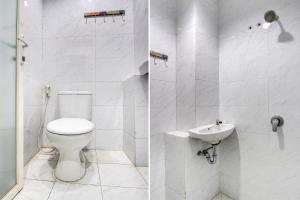 uma casa de banho branca com um WC e um lavatório em OYO 92479 Pasadena House em Semarang