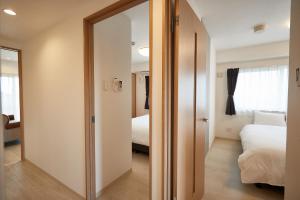 uma sala com uma porta que leva a um quarto em New Normal Hotel in NAGO ニューノーマルホテルイン名護 em Nago